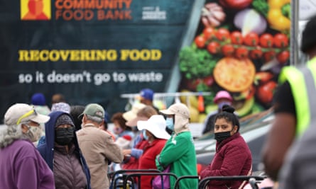People wait in line to receive packages of food during a food bank giveaway in Oakland, California.