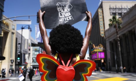 A protester strikes a pose while holding a Black Lives Matter sign on Hollywood Boulevard during the All Black Lives Matter solidarity march, replacing the annual gay pride celebration, on Sunday in Los Angeles.