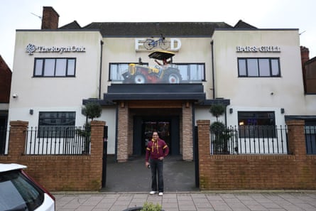 A man stands outside his pub