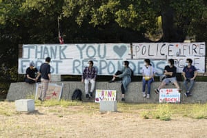 Students and researchers at UC Santa Cruz sit in front of a sign thanking first responders, on 24 August.
