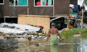 A woman wades through water on Funafuti Atoll, the capital of Tuvalu, which has been hit hard by climate change in the form of increased storms, flooding of low-lying areas and significant erosion.