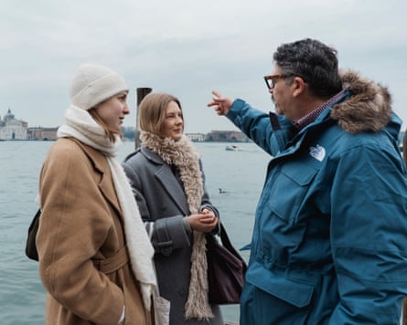 Scomparin pointing while talking to two women