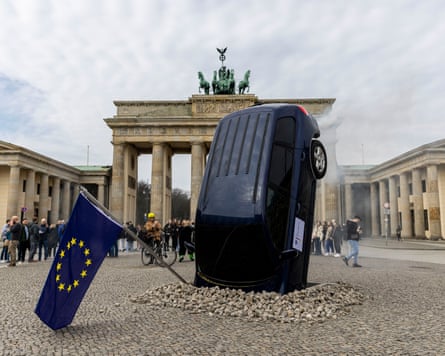 An installation by Greenpeace activists shows an SUV that is seemingly rammed into the pavement in front of the Brandenburg Gate, Berlin, Germany