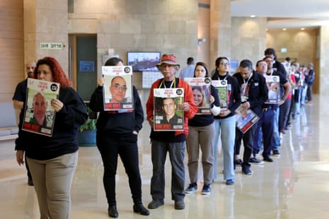 Family members of Israeli hostages carry pictures of their loved ones at the Knesset in Jerusalem.