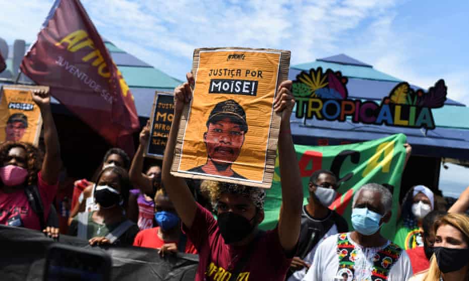 A demonstrator carries a banner during a protest against the death of Congolese refugee Moïse Mugenyi Kabagambe.