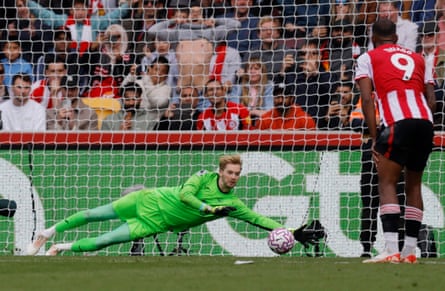 Caoimhín Kelleher dives to save Bruno Fernandes, watched by Igor Thiago.