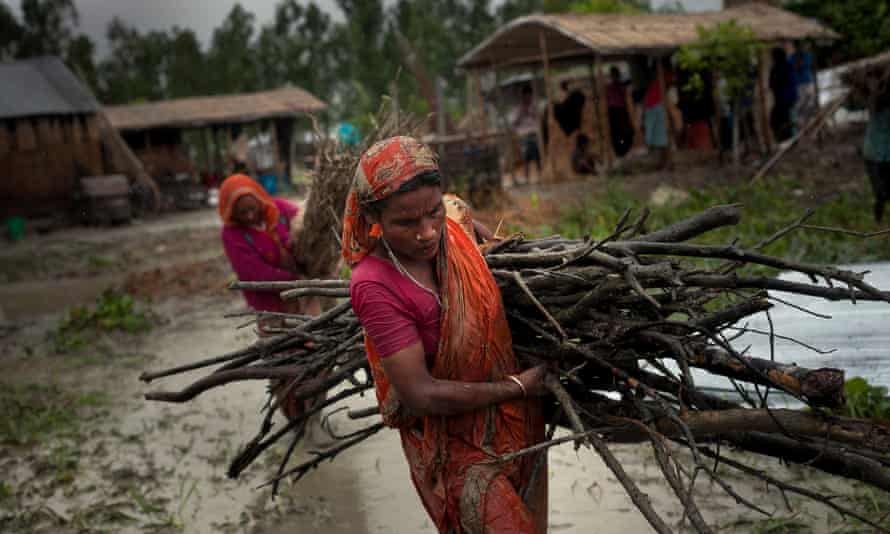 Women move possessions from their homes, under threat of flooding, September 2014.
