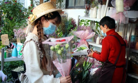 People shop in a flower market in Suzhou, one of the cities where the digital currency will be trialled.