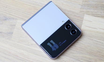 O Samsung Galaxy Z Flip 4 mostrando a tela da capa iluminada para exibir a hora e a data.