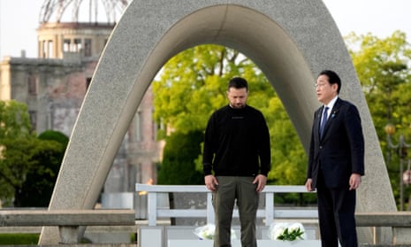 Volodymyr Zelenskiy (left) and the Japanese prime minister, Fumio Kishida, talk after laying flowers in front of the cenotaph in Hiroshima