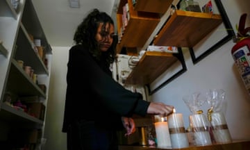 A woman lights candles in her store after a programed power cut ordered by the ministry of energy, in Quito, Ecuador, Tuesday, April 16, 2024. Ecuador faces electricity rationing due to a prolonged drought and high temperatures that have reduced flows to the main hydroelectric plants. (AP Photo/Dolores Ochoa)