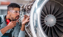 Aircraft Maintenance Mechanic Inspecting Jet Engine<br>Aircraft Maintenance Mechanic Inspecting and Working on Airplane Jet Engine in the Hangar.