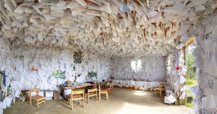 A room with sheets of paper pinned to walls and ceilings