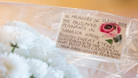 A dedication card and bouquet of flowers, left in July 2021 at Penrhyn Castle in memory of slaves