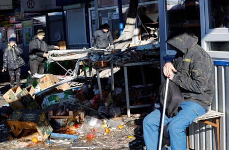 People remove debris at a food market in Donetsk following, what local Russian-installed authorities say, was a Ukrainian military strike.