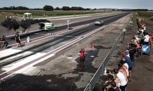 Supporters watch two competitors hare down the track.
