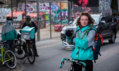 Three Deliveroo drivers can be seen on strike in a London street