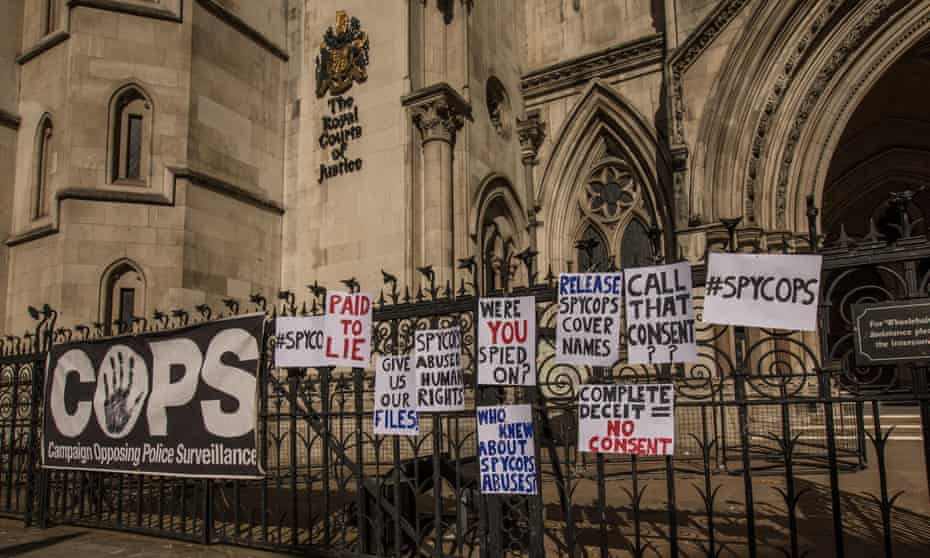 Signs outside Royal Courts of Justice reading Paid to lie Release spycops cover names Call that consent Complete deceit  no consent etc