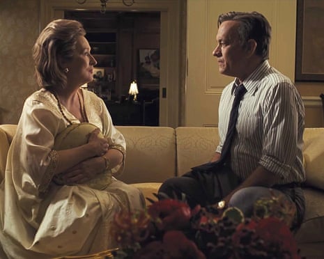 Meryl Streep in a white nightgown, clutching a pillow, sitting facing Tom Hanks, in a tie and shirtsleeves, on a couch.