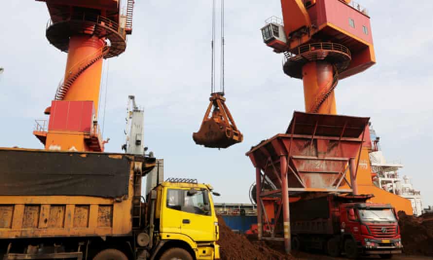 Imported iron ore being unloaded from a ship at a port in Lianyungang, Jiangsu Province of China.