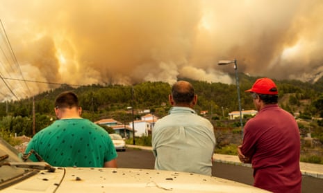 Local residents look on at a burning forest fire near Puntagorda on the Canary island of La Palma