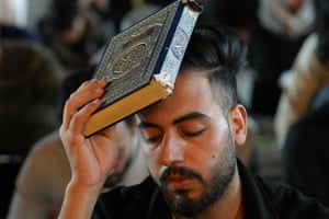 A Shia Muslim places the Qur’an on his head during prayer rituals