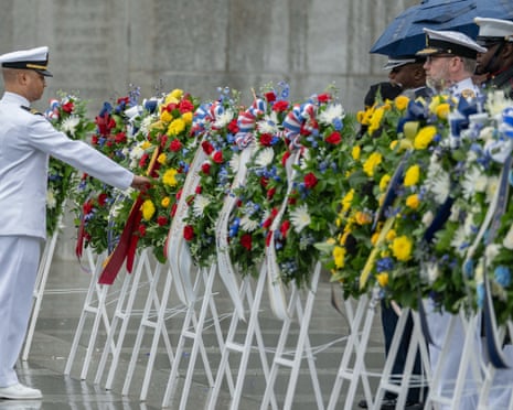 Men in uniform near floral wreaths