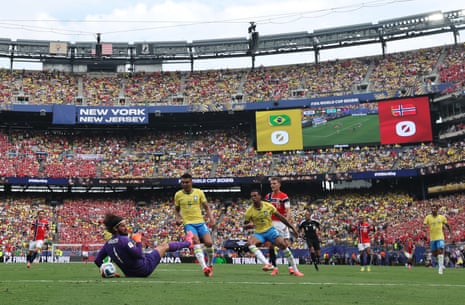 Alisson of Brazil saves a shot taken by Martin Odegaard of Norway.