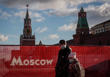 People wearing protective face masks walk on the Red Square in Moscow as Russia records a new pandemic record one-day high of 1,211 deaths due to Covid-19.