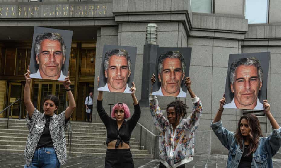 A protest group holds up photos of Jeffrey Epstein in front of the courthouse in New York City on 8 July 2019.