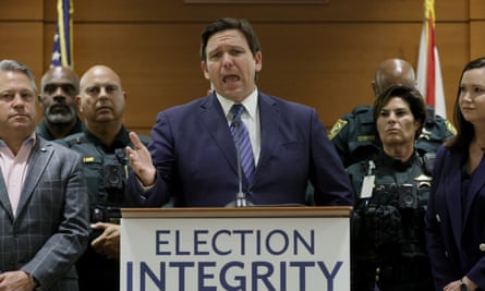 desantis speaks at podium surrounded by others