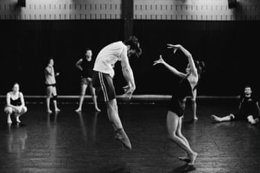 A black and white photograph depicts two dancers in rehearsal