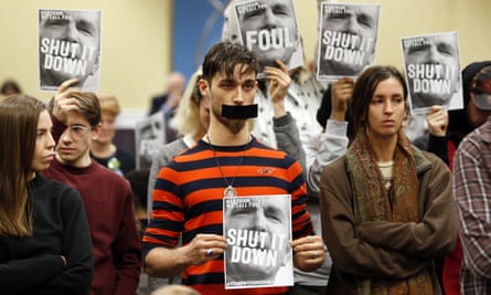 Protesters hold signs as they turn their backs on a meeting of the Virginia State Air Quality Control Board in Richmond, Va.