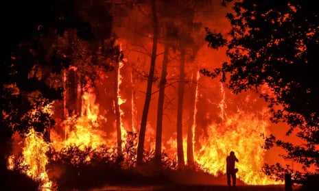 The silhouette of a person is seen in front of flames at a wildfire near Belin-Beliet in south-west France, overnight on 11 August.