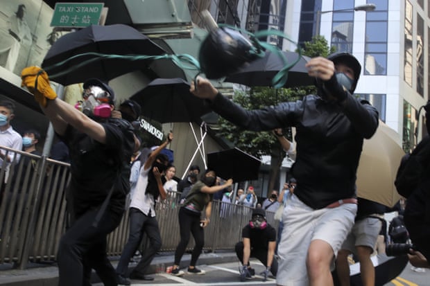 Protesters use a catapult to launch a milk carton at riot police during protests in the Central district of Hong Kong on Monday.