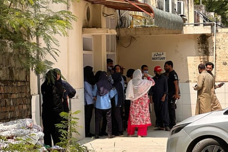 People gather outside the Pakistan Institute of Medical Sciences hospital mortuary