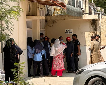 Relatives of the victims gather outside the mortuary of the Pakistan hospital after the fire.