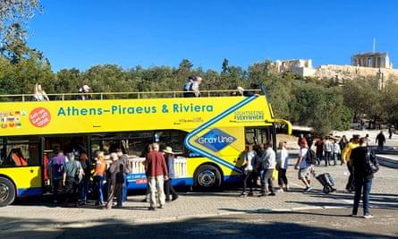 Tourists board a bus beneath the ancient Acropolis in Athens.