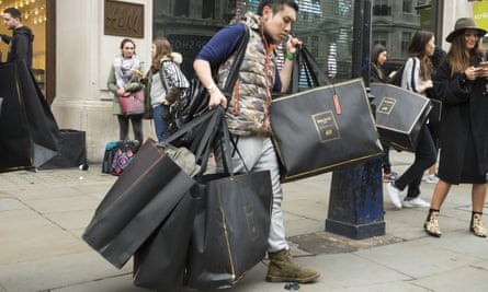A shopper laden with bags as he emerges from H&M.