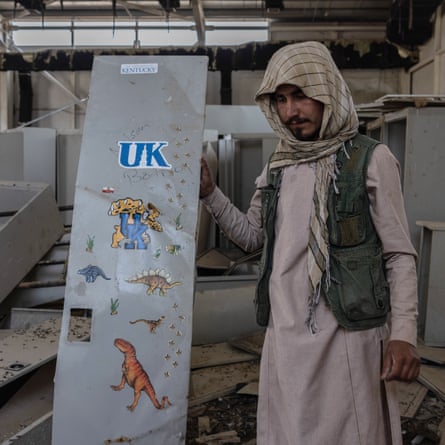A Taliban fighter in Ghazni holds up a locker door at a former US base, on September 2021. The base is now controlled by the Taliban.