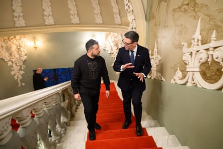 Andy Burnham and Volodymyr Zelenskyy walk up a staircase in an ornately decorated building in Kyiv. They are talking. There is a red strip of carpet running up the stairs.