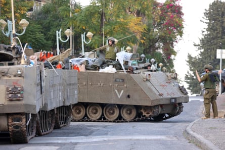 Israeli soldiers in tanks patrol an area near the northern border with Lebanon