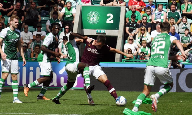 Lawrence Shankland of Hearts holds off a challenge.