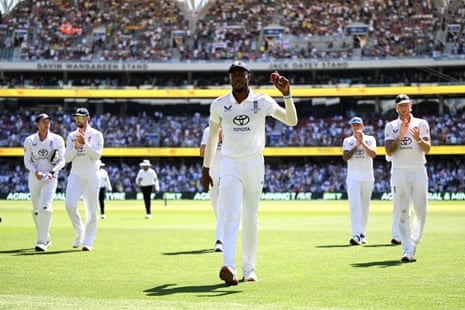Archer of England holds up the ball as he leaves the field.