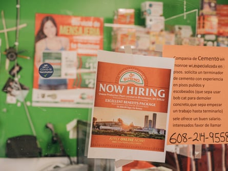 Orange signs advertising job openings in English and Spanish hang on a clear partition at the Veracruz Mexican market.