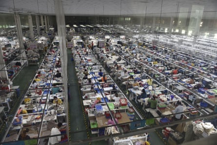 View of people working in rows of cubicles on a huge factory floor