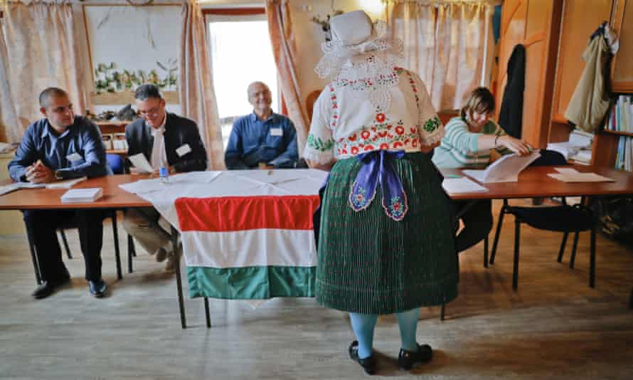 Edit Piros, an ethnic Hungarian from Romania, who moved to Hungary from Transylvania, receives the ballot paper before voting in the referendum in the village of Veresegyhaz, Hungary.