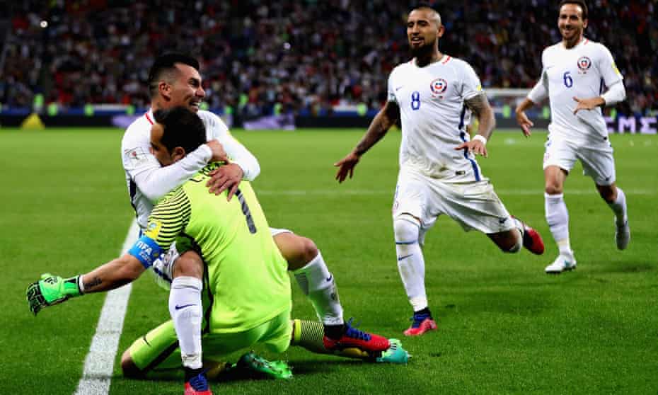 Claudio Bravo is swamped by his Chile team-mates after thwarting Portugal in a penalty shootout to take his nation into the Confederations Cup final. 