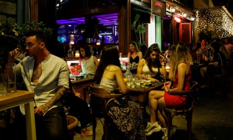 People sit at a bar in Athens, Greece.