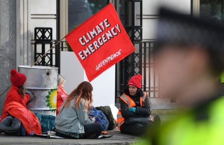 Greenpeace activists chain themselves to oil barrels outside BP’s headquarters in London.